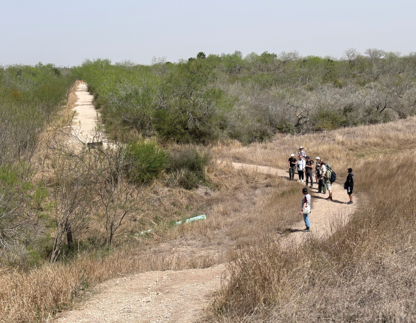 Students walk a sunny hike and bike trail in the Rio Grande Valley near Pharr Texas 