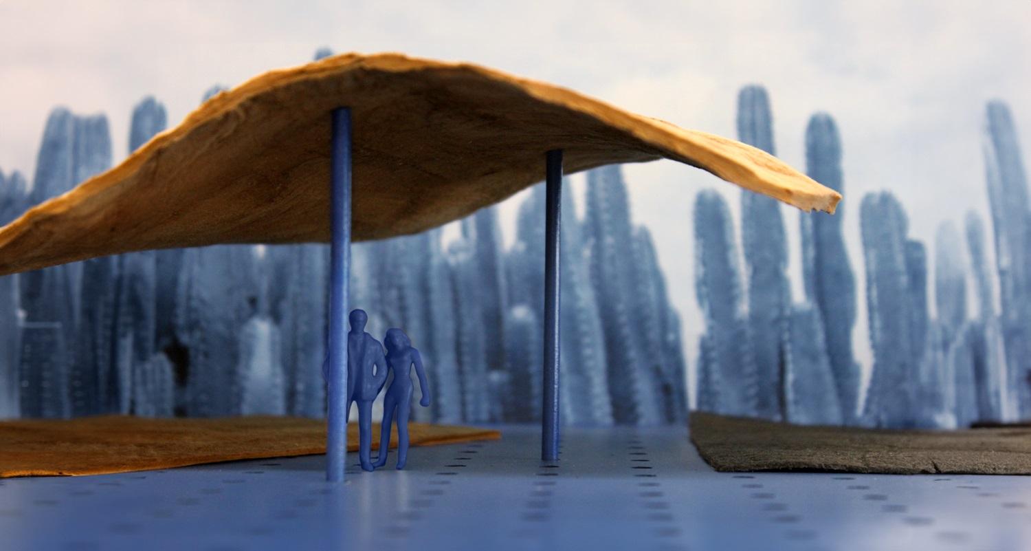 Close up of a diorama model with two blue figures standing under an awning with blue cactus looking structures in the background