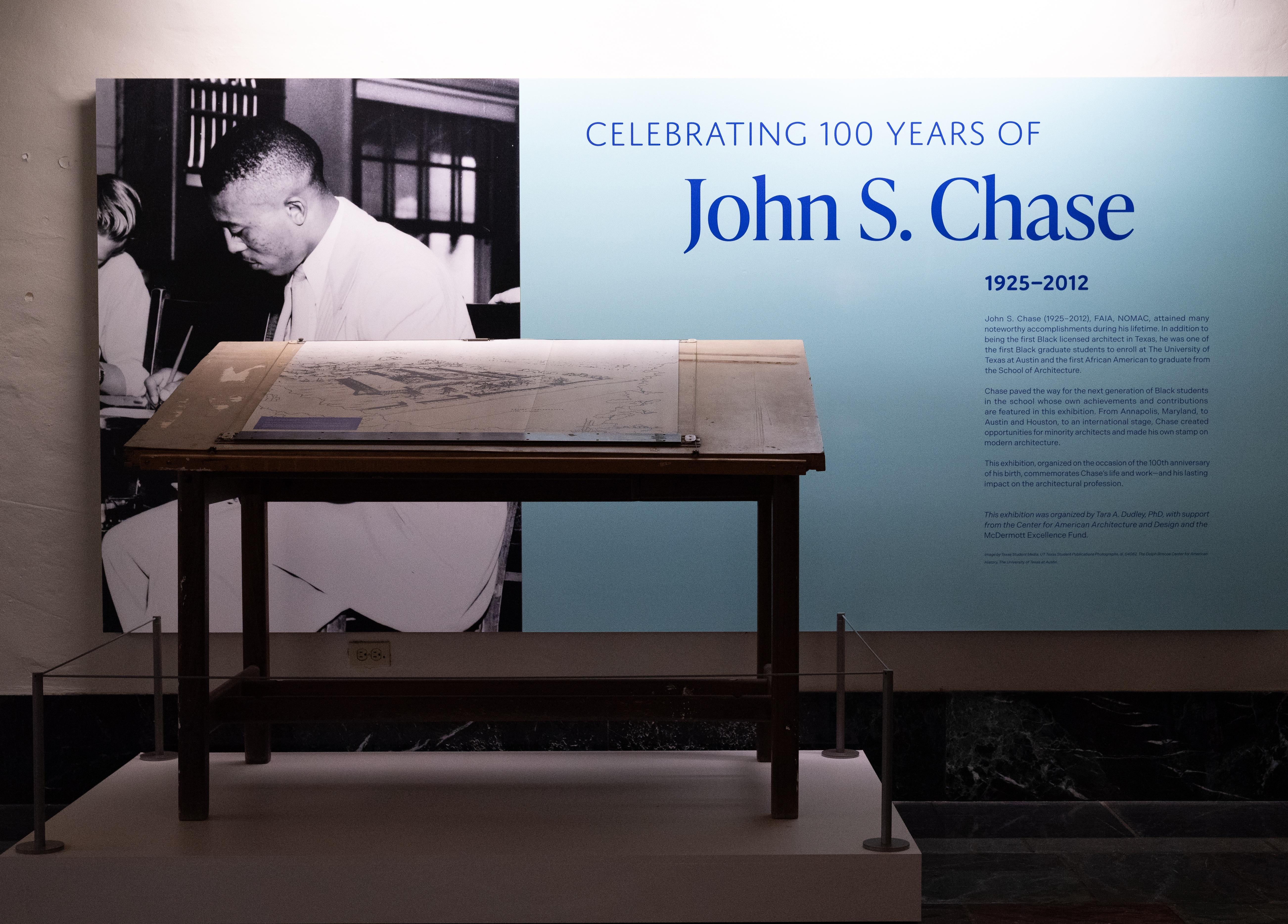 Photograph of exhibition title wall featuring John S. Chase's drafting table
