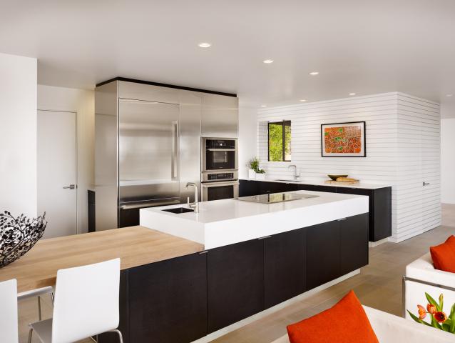 Interior shot of a kitchen island with dark cabinetry and wood countertops