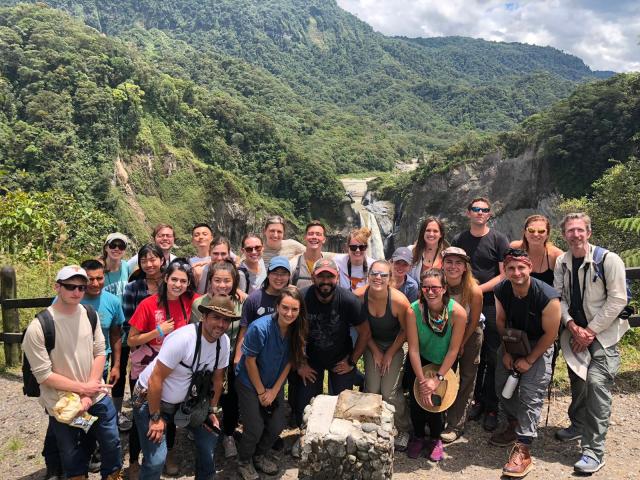 Group shot of students in Ecuador in front of rolling green hills