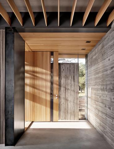 An exterior hallway of a home designed by Kevin Alter's professional practice featuring a mixture of different warm materials and textures