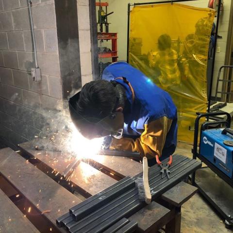 A student welding in the Build Lab