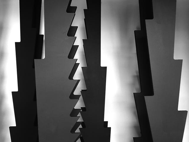 Black and white abstract jagged shaped materials reflecting shadows on a wall