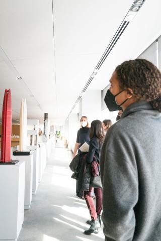 Side view of students looking at sculptural models across from them.