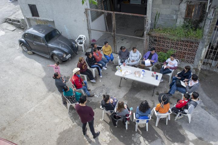 Overhead shot of students sitting in a circle with residents in the street in Monterrey, Mexico