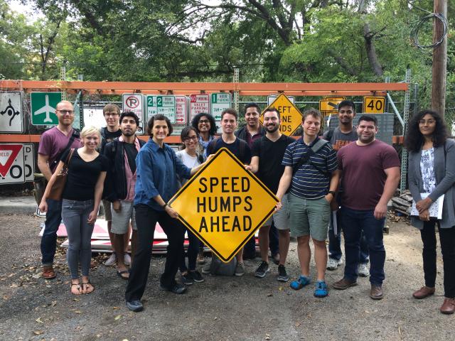 Students behind a Speed Humps Ahead sign