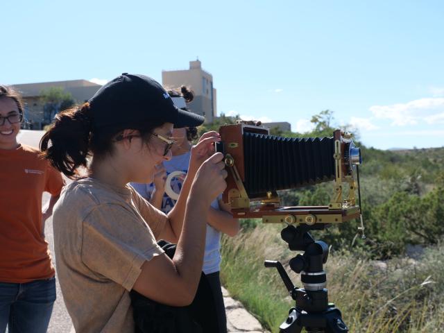 A student interacting with a large-format camera