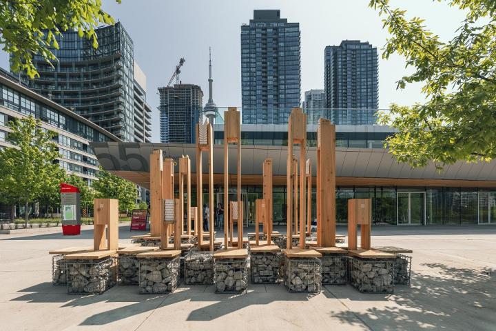 An installation of several pieces of wood furniture/structures in the middle of downtown Toronto.