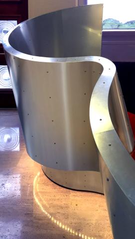 Curved, metal sculptural front desk