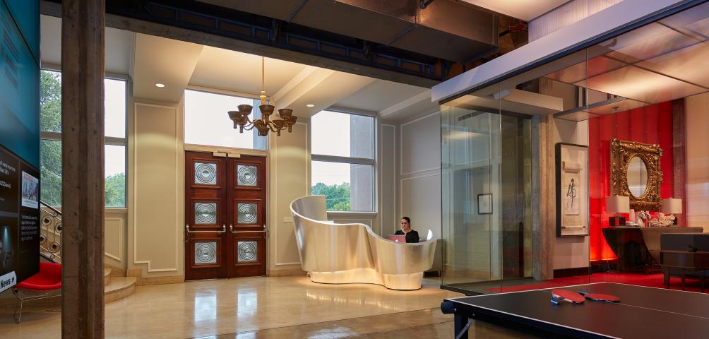 Entryway of a hospitality building with a sculpturesqe front desk