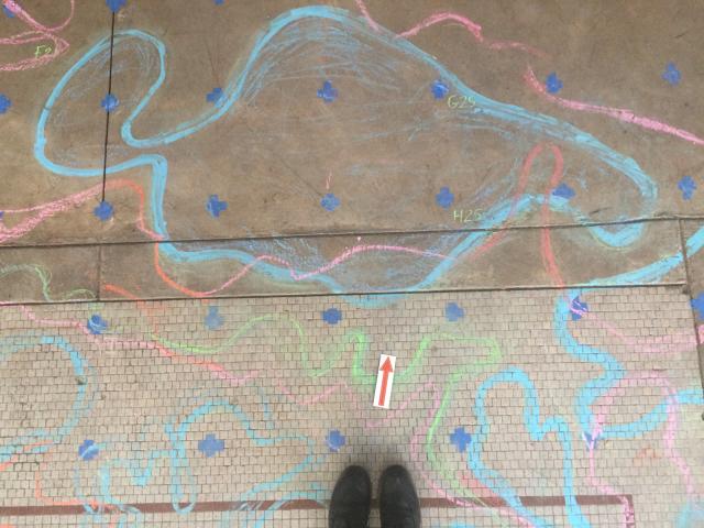 Shoes on a sidewalk with chalk squiggles