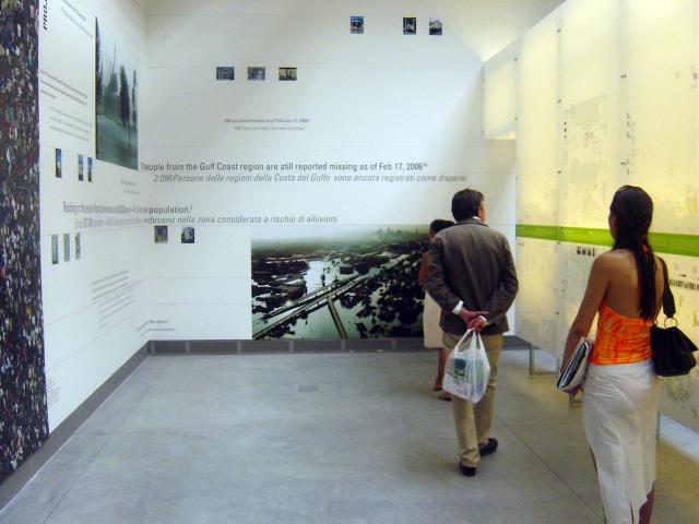 Two people viewing a large gallery installation about a gulf coast project.