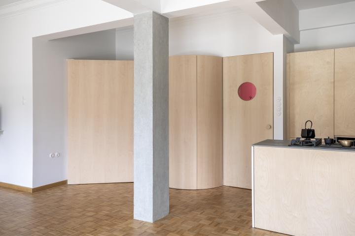 Appartment interior in Victoria Square, Athens, Greece. Custom cabinetry, restored wood floor, and exposed concrete column at entrance hall.
