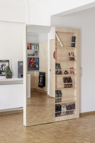 Appartment interior in Victoria Square, Athens, Greece. Custom pivot door with mirror and storage at entrance hall.